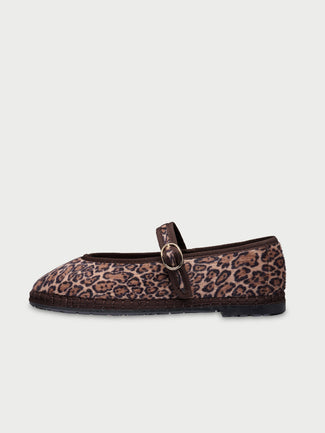 White sneaker with brown sole on a light beige background