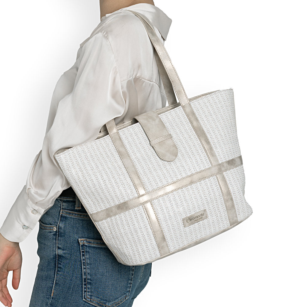 Person holding a white woven tote bag with beige accents on a plain background