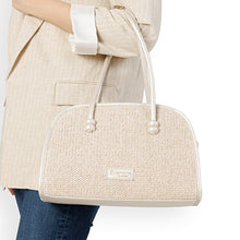 Load image into Gallery viewer, Beige textured handbag held by a person wearing a beige coat and blue jeans on a white background
