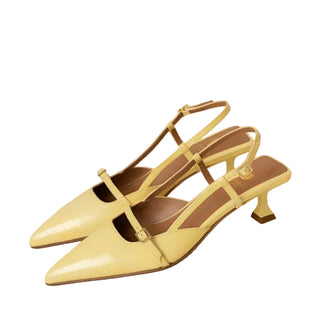 Pair of yellow high-heeled shoes on a beige background