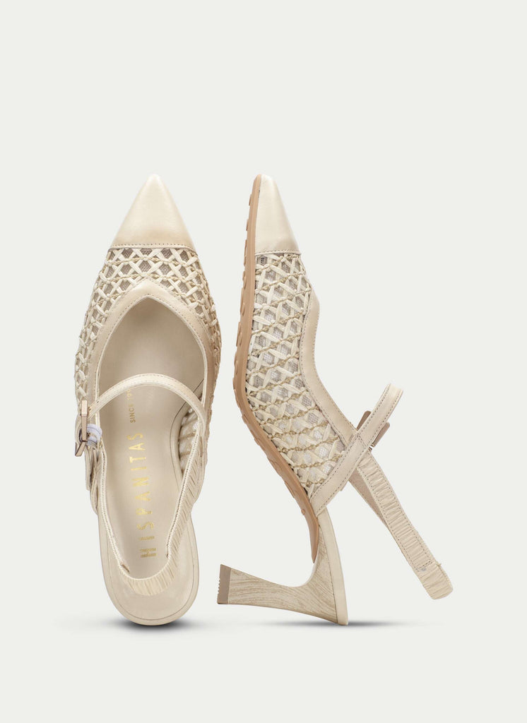 Pair of beige high-heeled shoes with detailed design on a light gray background