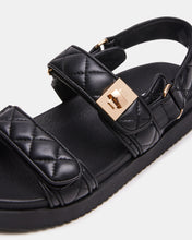 Load image into Gallery viewer, Black quilted sandal with a gold buckle on a light gray background
