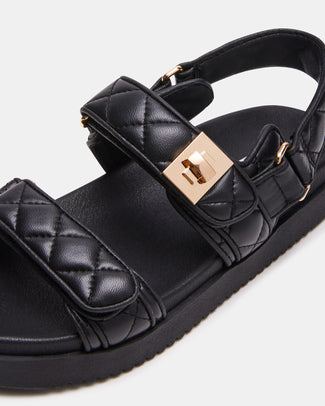 Black sandal with gold buckles on a white background
