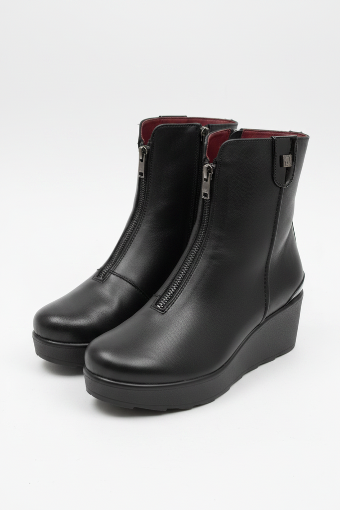 A pair of black leather ankle boots with wedge heels and side zippers, photographed on a plain light background.