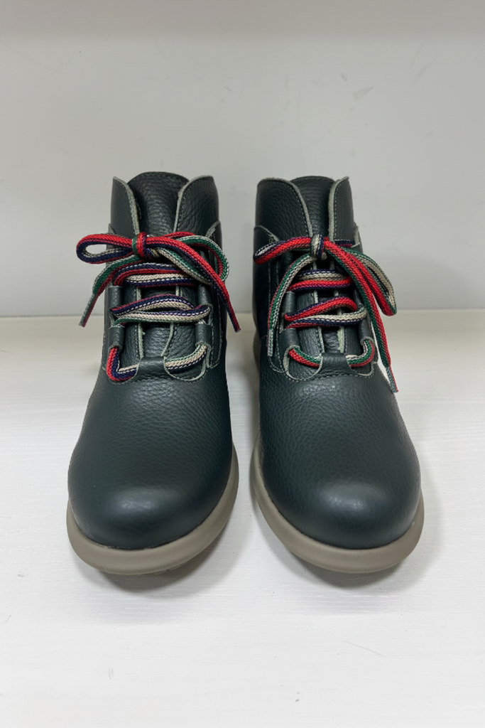 A pair of dark green pebbled leather ankle boots with multicolor striped laces (red, green, and white) and light brown soles, shown against a plain white background.