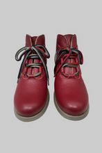 Load image into Gallery viewer, A pair of red pebbled leather ankle boots with colorful striped laces, photographed against a plain white background.
