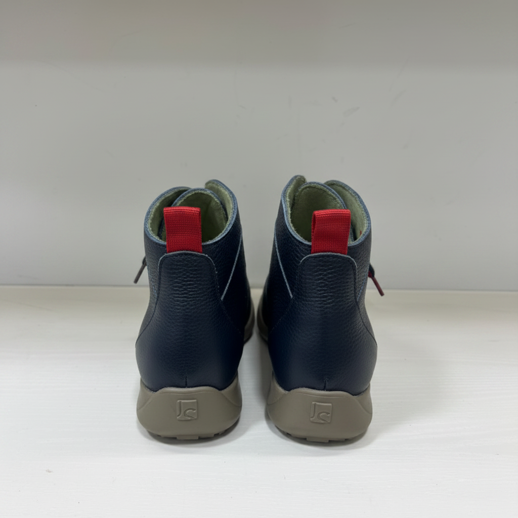 A pair of dark navy blue leather ankle boots shown from the back, featuring light gray soles and a green interior lining.
