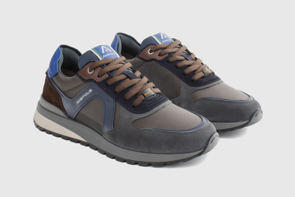 Pair of gray and brown sneakers with blue accents on a light gray background