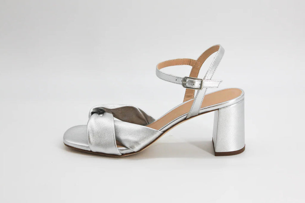 Silver sandal with a block heel on a light gray background
