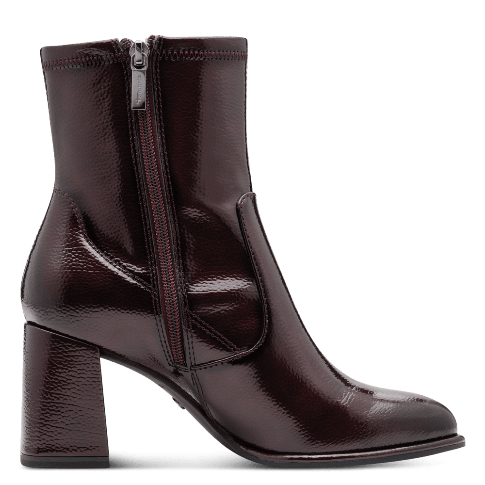 Burgundy patent leather ankle boot with a block heel on a transparent background