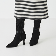 Load image into Gallery viewer, Black high-heeled boots worn with a striped coat on a white background
