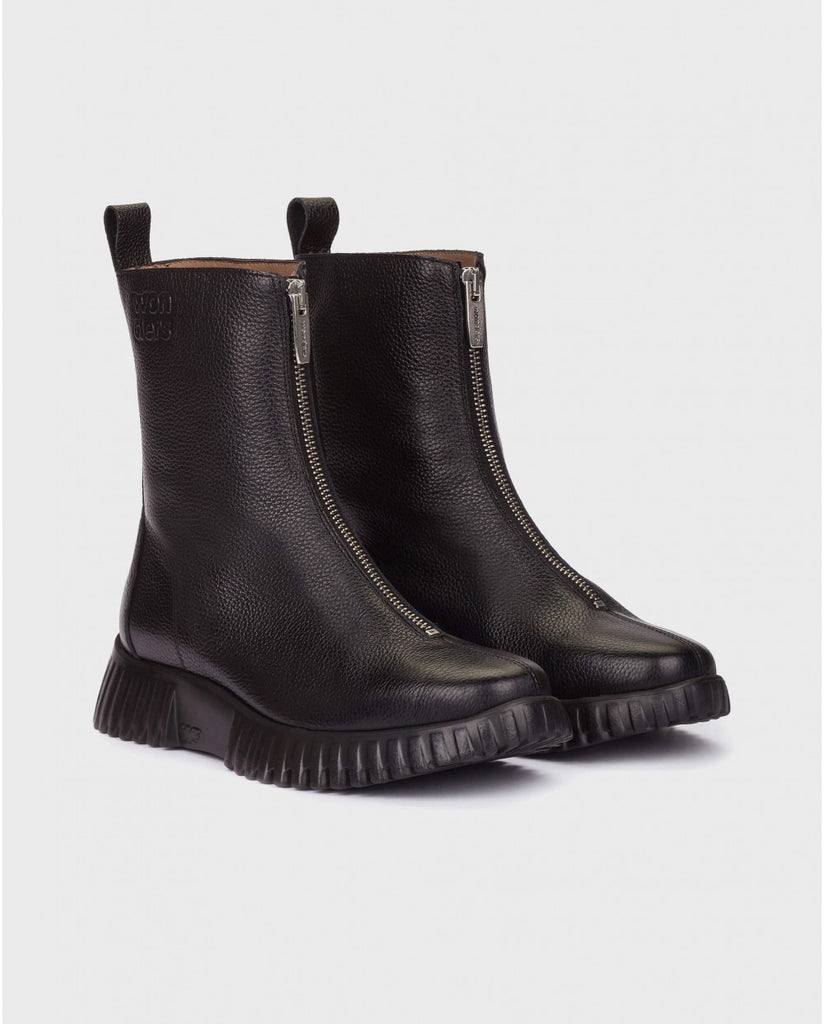 Pair of black leather boots with zippers on a light gray background