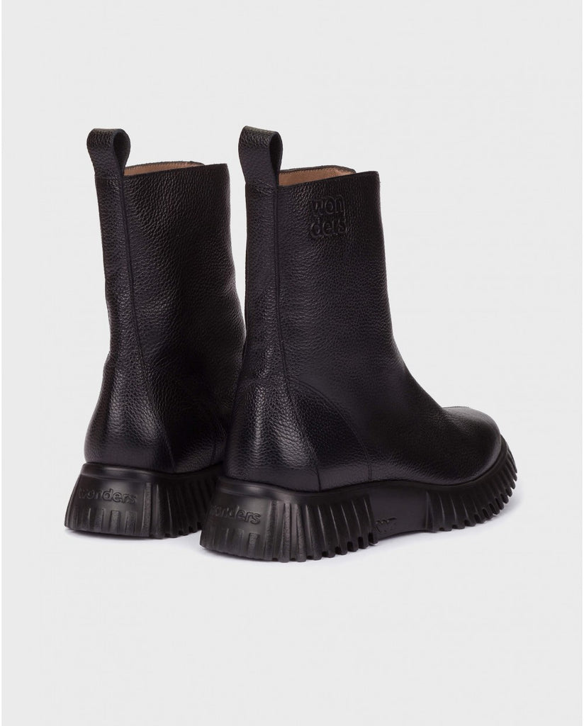 Pair of black leather boots on a light gray background