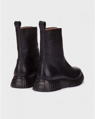 Black leather boot on a light gray background