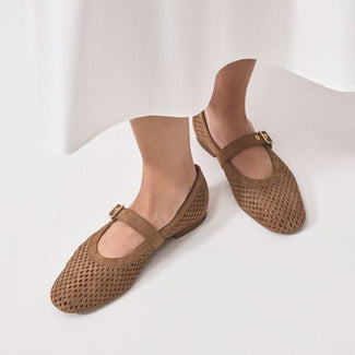 Brown flat shoe with a buckle on a white background