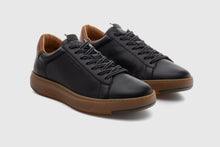 Load image into Gallery viewer, Black sneakers with brown soles on a light gray background
