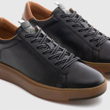 Load image into Gallery viewer, Black leather sneakers with brown soles on a light gray background
