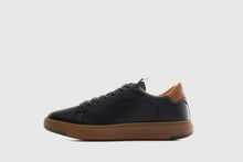 Load image into Gallery viewer, Black leather sneaker with brown sole on a light gray background
