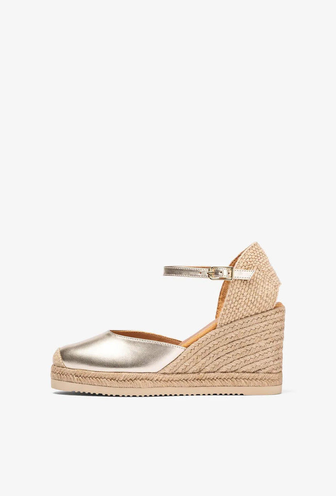 Gold wedge sandal with espadrille sole on a white background