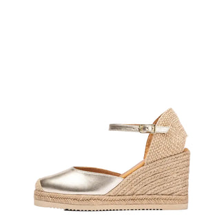 Gold wedge sandal with espadrille sole on a white background