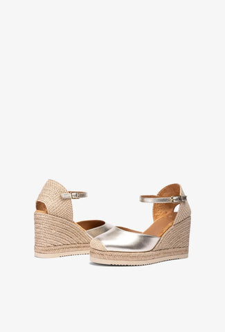Gold wedge sandal with espadrille sole on a white background