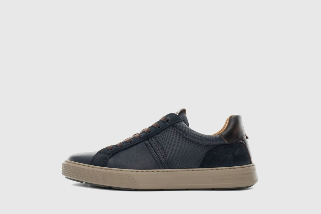 Navy blue sneaker with beige sole on a light gray background