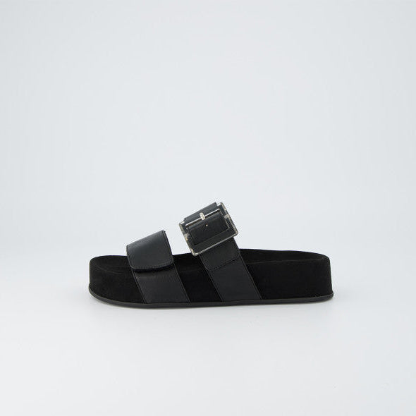 Black sandal with a buckle on a light gray background