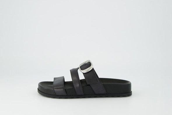 Black sandal with metallic buckle on a white background