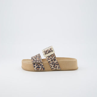 Leopard print sandals worn on a sandy background