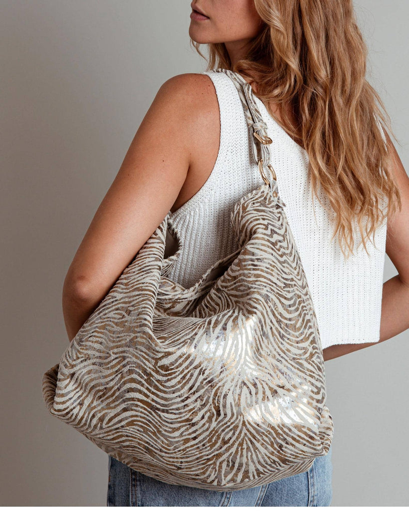 Woman carrying a zebra-striped handbag against a neutral background