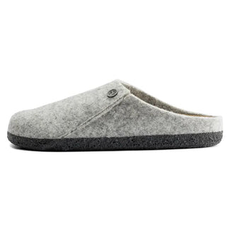 A light gray felt slip-on clog shoe with a dark gray textured sole and a small metal logo button on the side, shown against a plain white background.