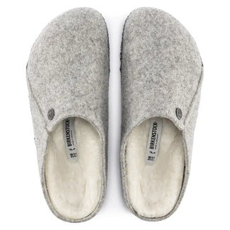 Gray felted wool slippers with a button on a white background