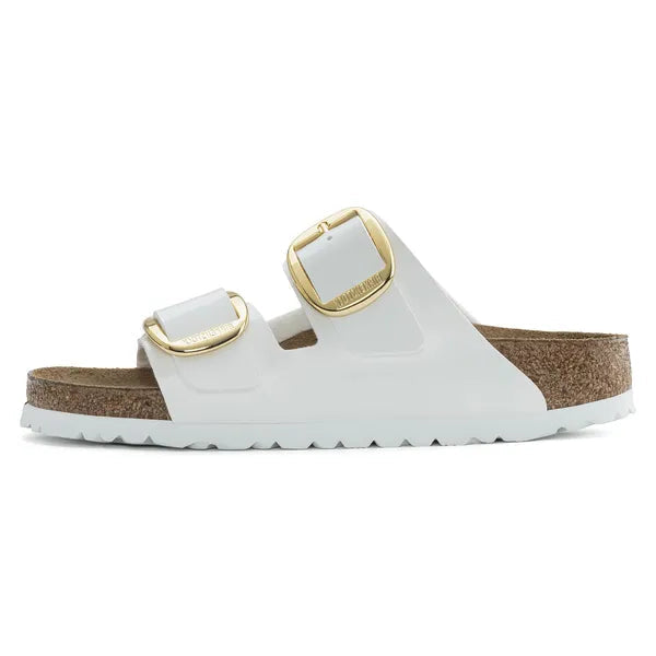 White sandal with gold buckles on a white background