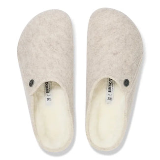 Beige slipper with a black sole on a white background