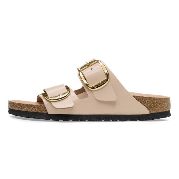 Beige sandal with gold buckles on a white background