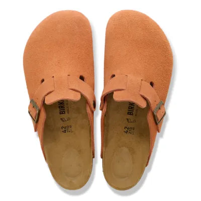 Pair of orange suede shoes with 'Birkenstock' branding on a white background