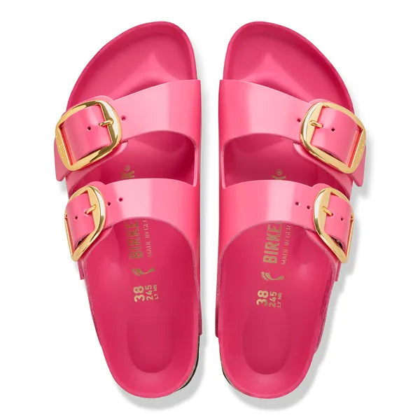 Pink sandals with gold buckles on a white background