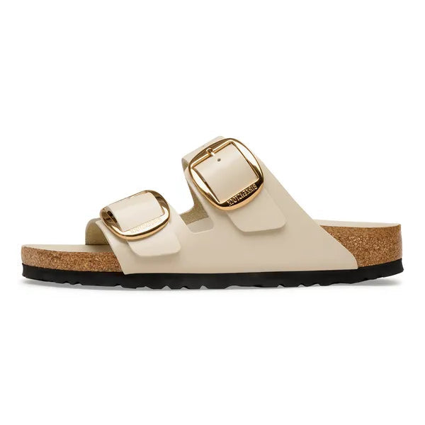 Beige sandal with gold buckles on a white background