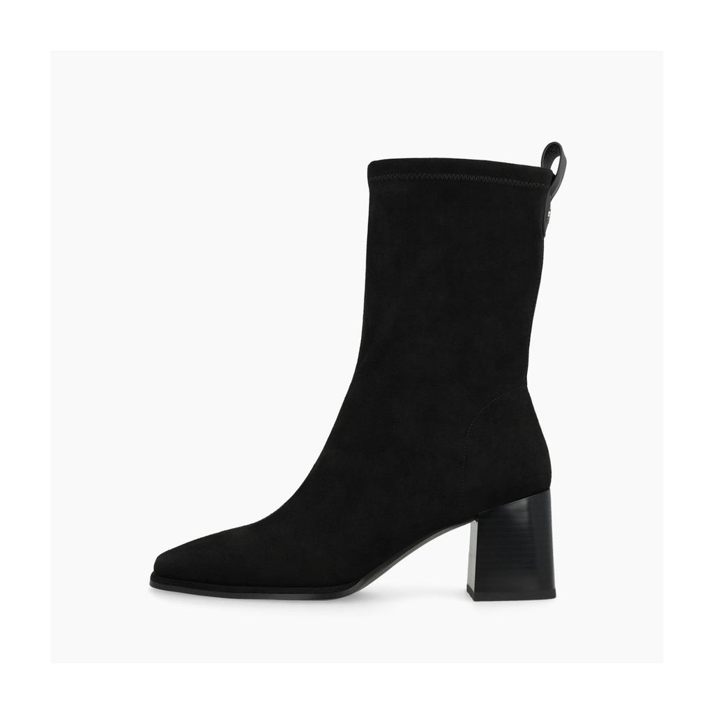 A black suede ankle boot with a chunky block heel and a pull tab at the back collar, shown in profile against a light gray background.
