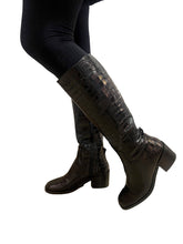 Load image into Gallery viewer, Person wearing black knee-high boots with a textured pattern on a tiled floor.
