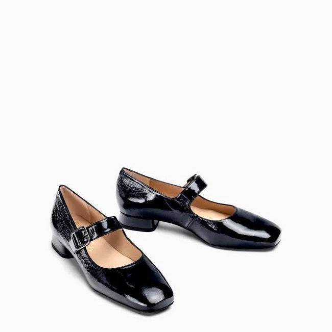 A pair of black patent leather Mary Jane shoes with low block heels and buckle straps, displayed on a clean white background.