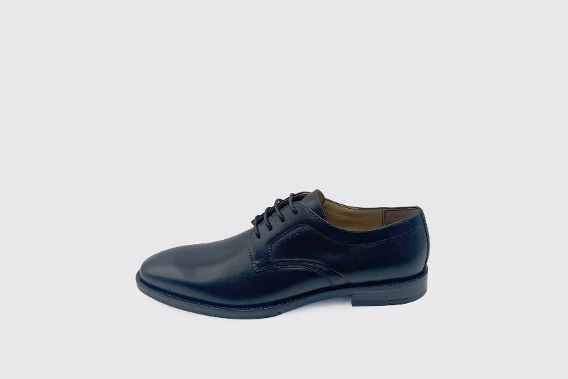 Black  leather shoe on a light gray background