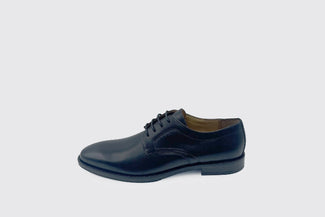 Black  leather shoe on a light gray background