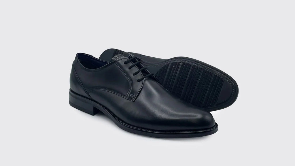 Pair of black leather dress shoes on a light gray background