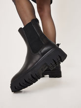Load image into Gallery viewer, Black Chelsea boots on a light gray background
