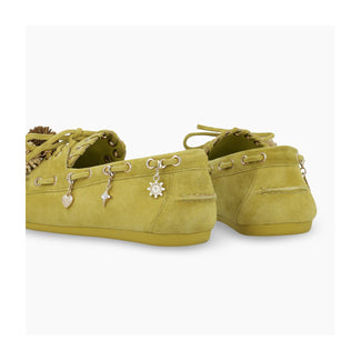 Green loafer shoe with charms on a light gray background