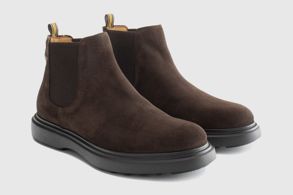 Pair of brown suede Chelsea boots on a light gray background