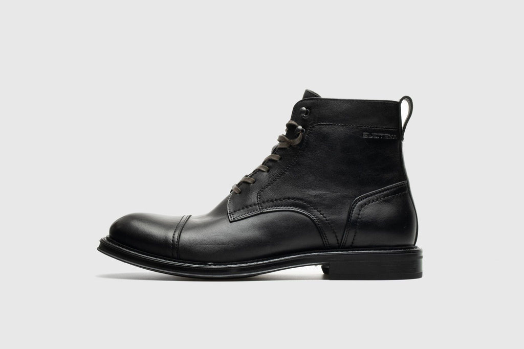 Black leather boot on a light gray background