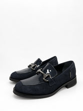 Load image into Gallery viewer, A pair of dark navy blue loafers with a mix of suede and patent leather panels, featuring a decorative silver-tone horsebit detail across the vamp, set against a plain white background.
