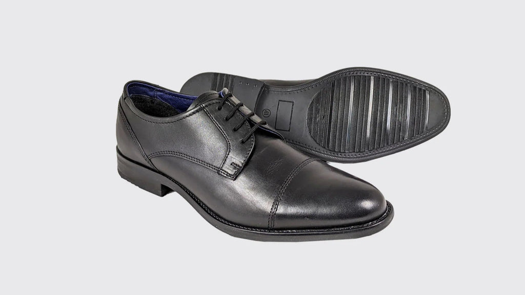 Pair of black dress shoes on a light gray background